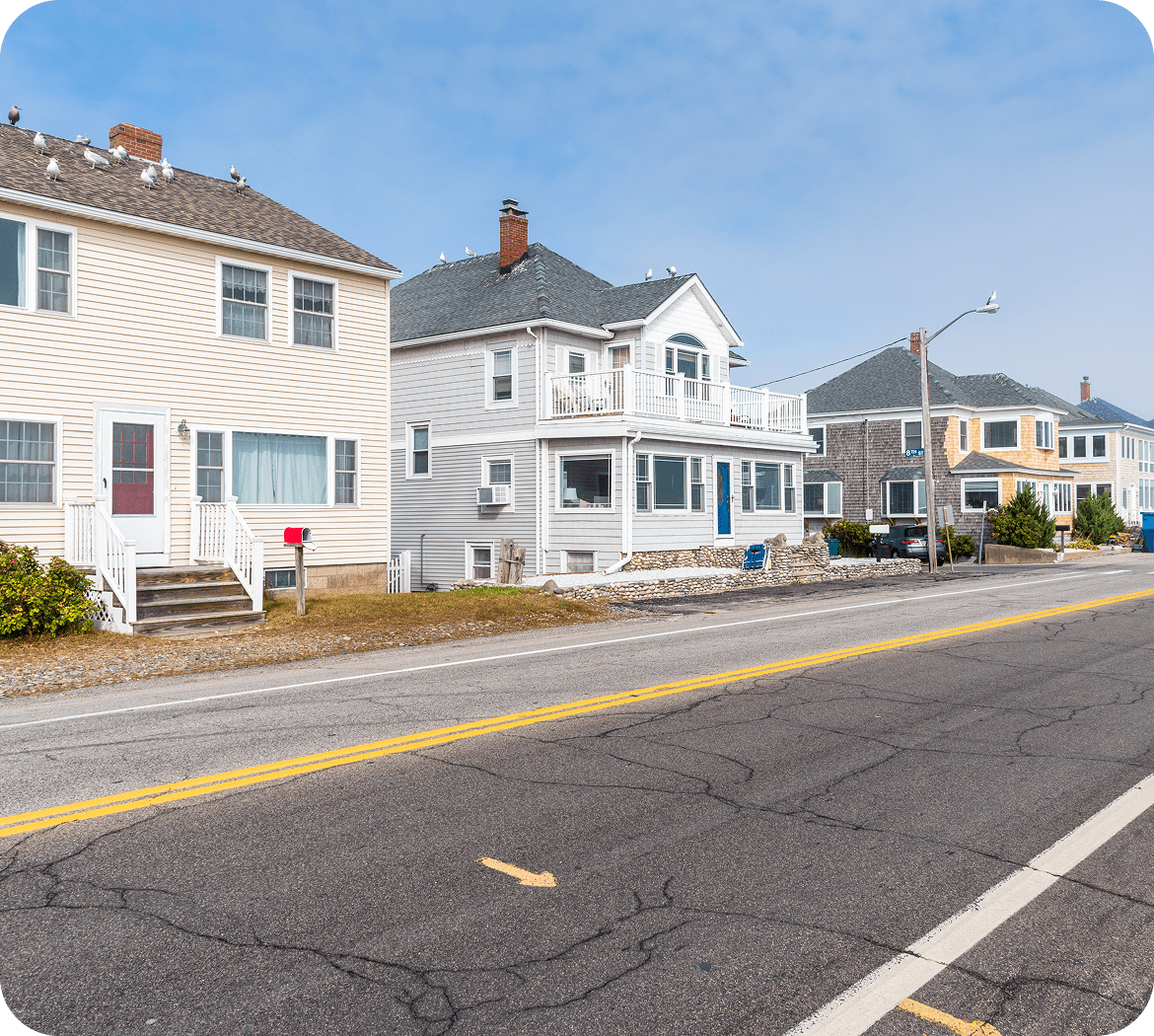 Coastal road with houses under clear sky.