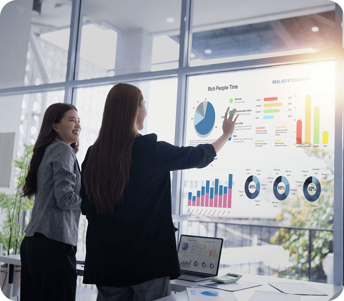 Two women analyzing digital business charts.